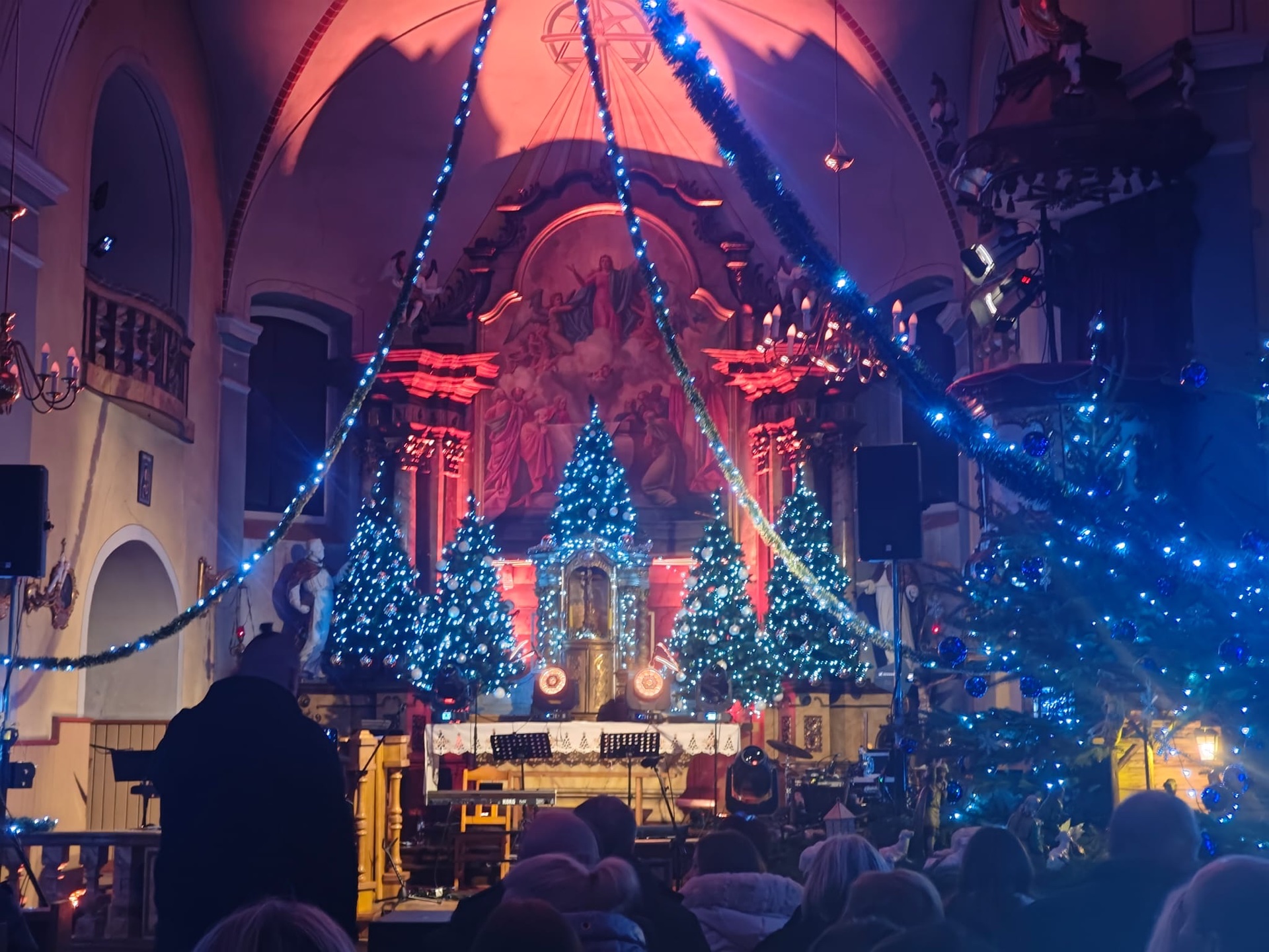 Koncert bożonarodzeniowy w kościele — choinki i światła