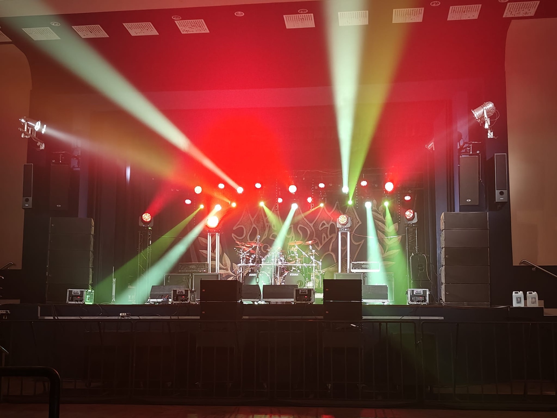 Koncert rockowy w hali — czerwono-zielone beams